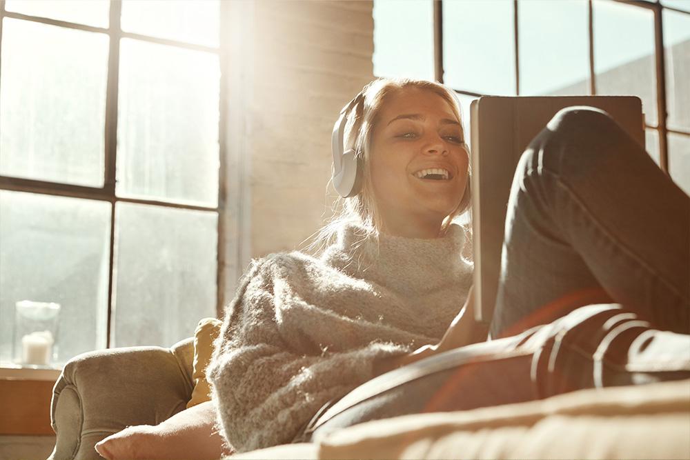 vrouw geniet van de warmte van de zon in haar duurzaam huis.