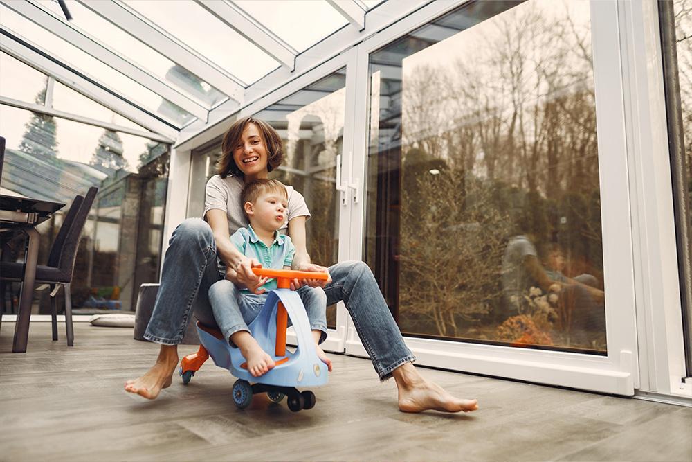 vrouw geniet van tijd met kind in duurzaam verwarmd huis met zicht op de tuin